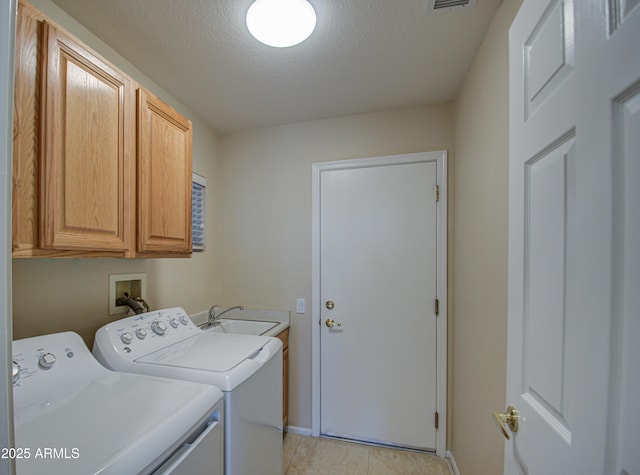 laundry area with sink, washer and clothes dryer, cabinets, and a textured ceiling