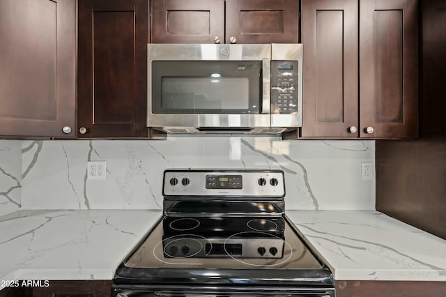 kitchen featuring decorative backsplash, dark brown cabinets, stainless steel appliances, and light stone counters