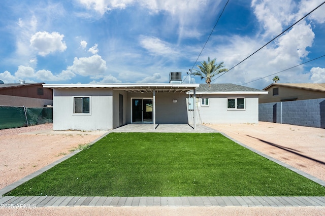 back of house featuring a lawn and a patio