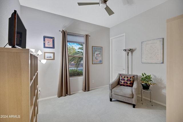 living area featuring light carpet and ceiling fan