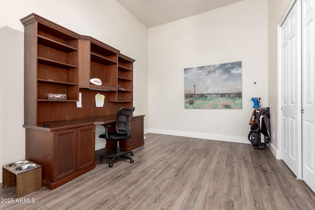 office space featuring built in desk and light hardwood / wood-style floors