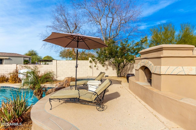 view of patio with exterior fireplace and a fenced in pool