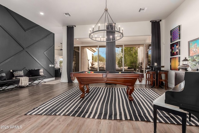 rec room with hardwood / wood-style floors, pool table, and a chandelier