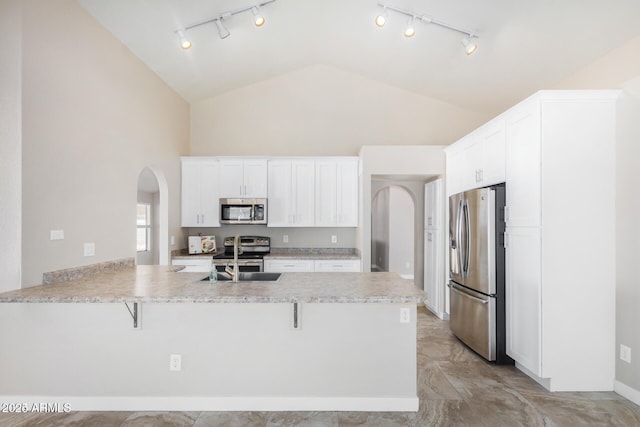 kitchen with white cabinetry, a kitchen breakfast bar, kitchen peninsula, and stainless steel appliances