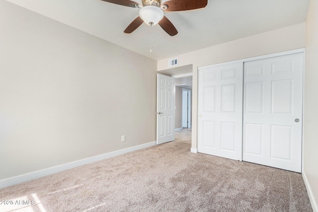 unfurnished bedroom featuring ceiling fan, a closet, and carpet flooring