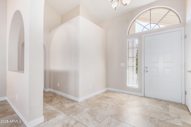 entryway with a wealth of natural light and a notable chandelier