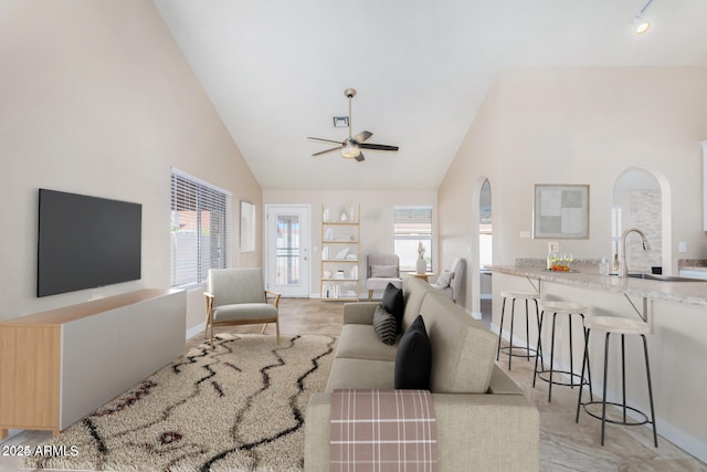 living room featuring high vaulted ceiling, sink, and ceiling fan