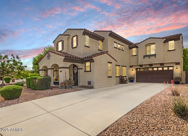 13088 N 91st Dr, Peoria, AZ 85381 - mediterranean / spanish-style house with driveway, stucco siding, a tiled roof, and an attached garage