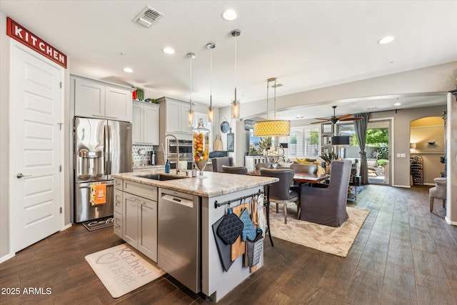 13088 N 91st Dr, Peoria, AZ 85381 - kitchen featuring appliances with stainless steel finishes, open floor plan, arched walkways, a ceiling fan, and dark wood-type flooring