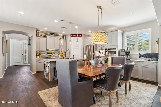 13088 N 91st Dr, Peoria, AZ 85381 - dining room featuring arched walkways, dark wood-style floors, and recessed lighting