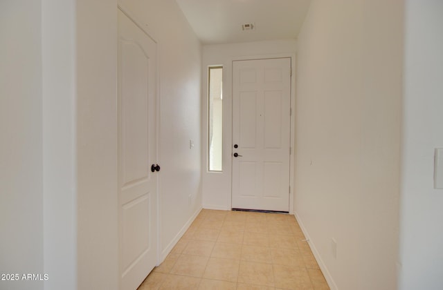 doorway with visible vents, baseboards, and light tile patterned floors