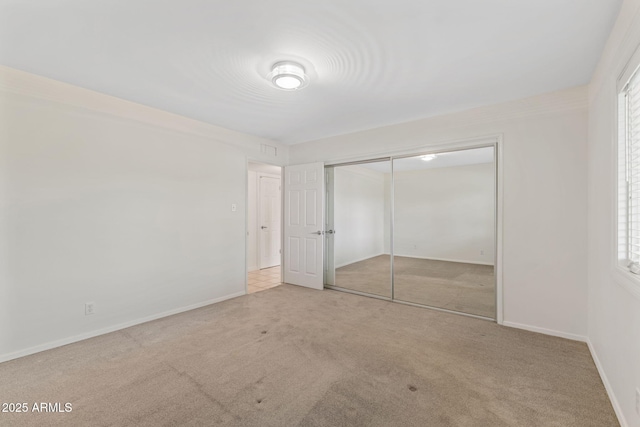 143 E Winter Dr, Phoenix, AZ 85020 - unfurnished bedroom featuring carpet, a closet, baseboards, and multiple windows