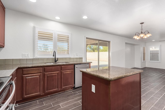 kitchen featuring sink, hanging light fixtures, a kitchen island, stainless steel appliances, and a chandelier