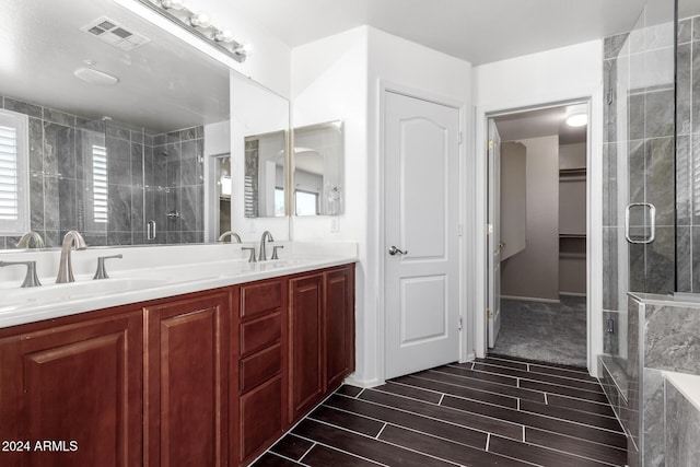 bathroom with vanity and a shower with door