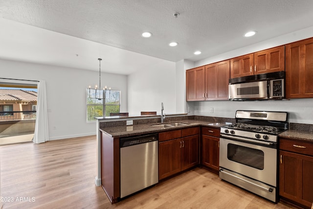 kitchen with an inviting chandelier, light hardwood / wood-style floors, appliances with stainless steel finishes, and sink