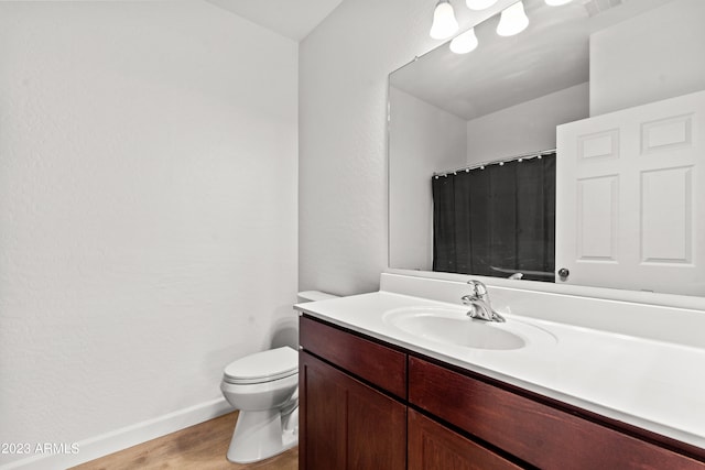 bathroom with vanity, toilet, and hardwood / wood-style flooring