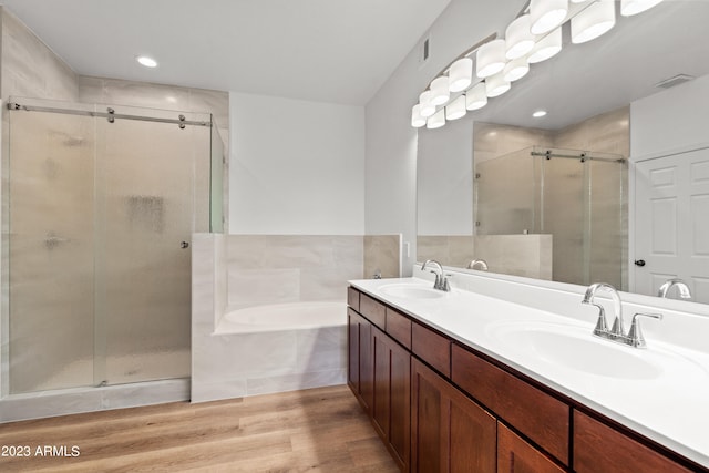 bathroom with shower with separate bathtub, vanity, and hardwood / wood-style flooring