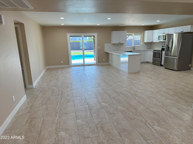 kitchen featuring light tile flooring, tasteful backsplash, stainless steel appliances, sink, and white cabinetry