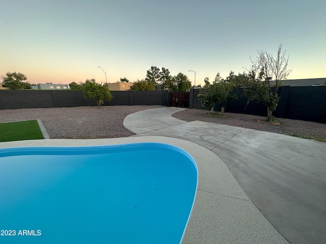 pool at dusk with a patio