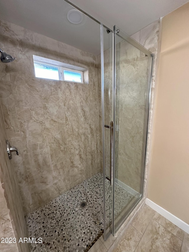 bathroom featuring tile floors and a shower with door