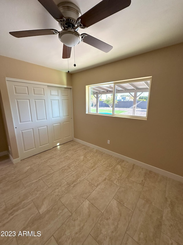 unfurnished bedroom featuring ceiling fan, a closet, and light tile floors