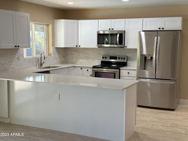 kitchen with white cabinets, backsplash, appliances with stainless steel finishes, and sink