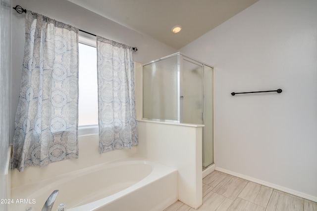 bathroom featuring tile patterned flooring, plenty of natural light, and separate shower and tub