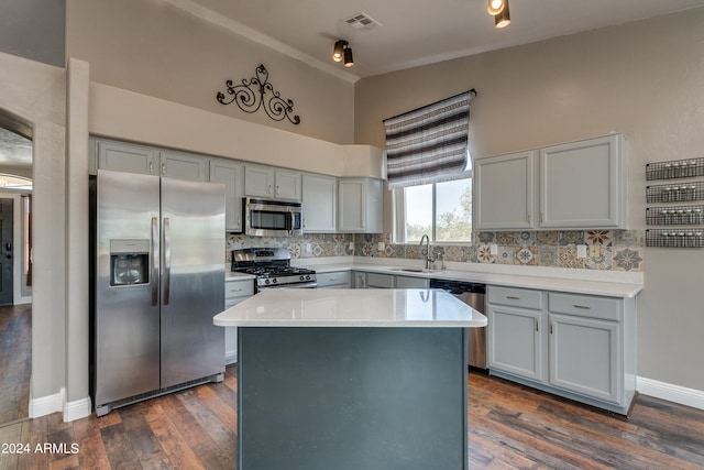 kitchen with stainless steel appliances, dark hardwood / wood-style flooring, decorative backsplash, a kitchen island, and sink