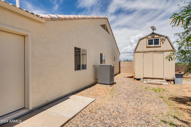 exterior space featuring cooling unit and a shed