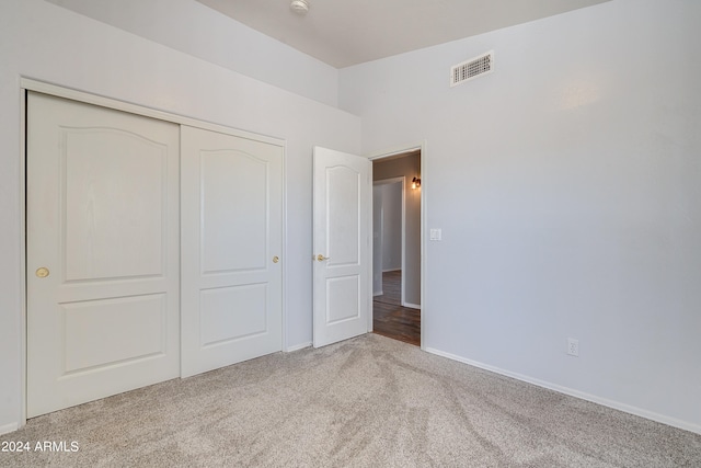 unfurnished bedroom featuring carpet flooring and a closet