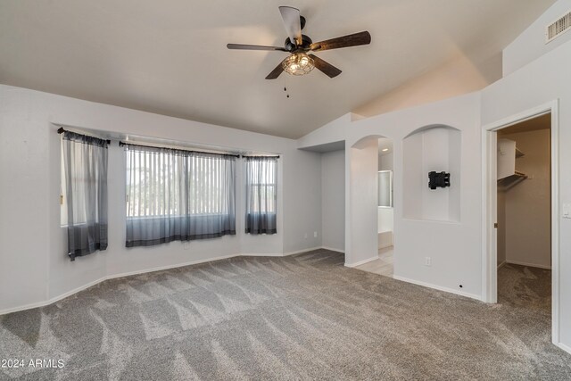 carpeted spare room featuring ceiling fan and vaulted ceiling