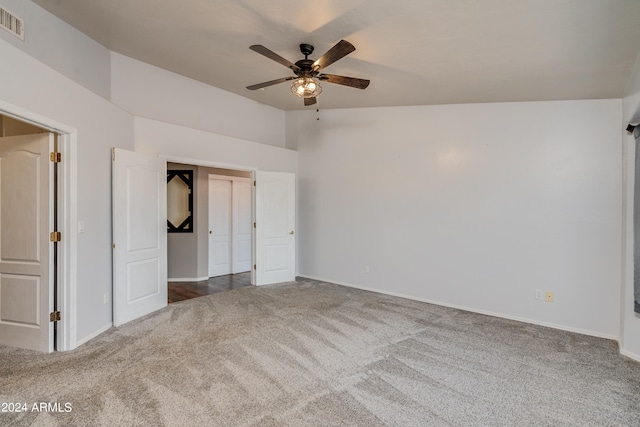 unfurnished bedroom with ceiling fan, carpet flooring, and vaulted ceiling