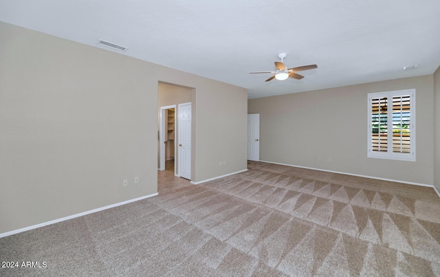 carpeted empty room featuring ceiling fan