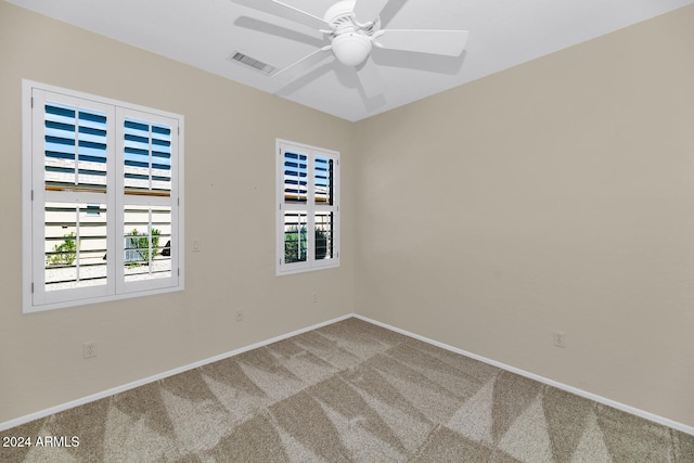 spare room with carpet floors, visible vents, baseboards, and a ceiling fan