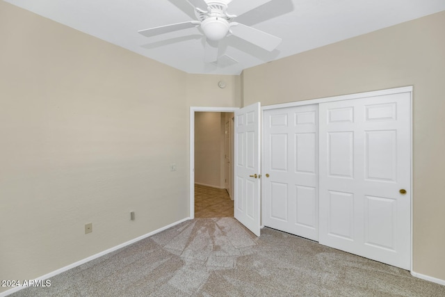 unfurnished bedroom featuring a ceiling fan, a closet, light colored carpet, and baseboards