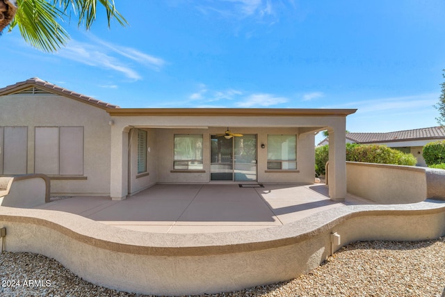 exterior space featuring stucco siding, a tiled roof, a ceiling fan, and a patio