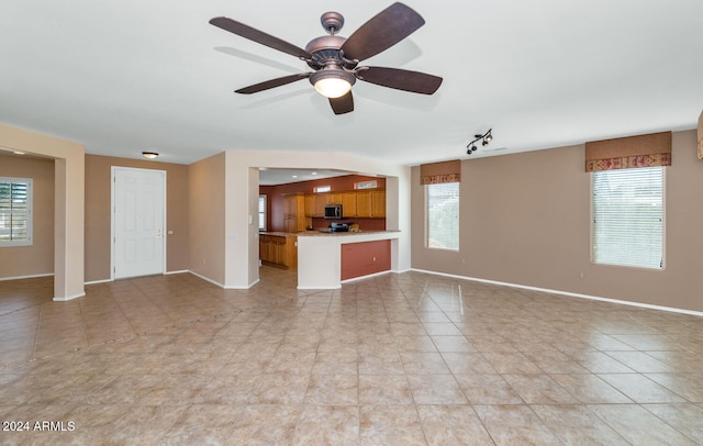 unfurnished living room featuring light tile patterned floors and ceiling fan