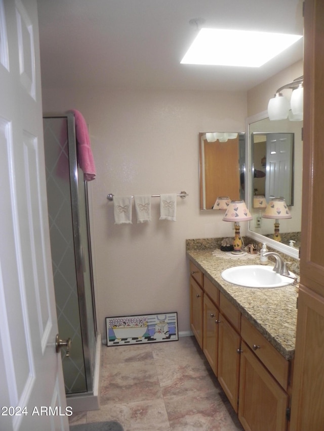 bathroom featuring vanity and a shower with shower door