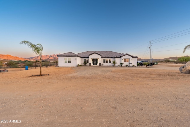 8017 S 143rd Ave, Goodyear, AZ 85338 - mediterranean / spanish house featuring a mountain view, a tiled roof, and stucco siding