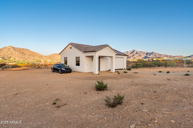 8017 S 143rd Ave, Goodyear, AZ 85338 - back of property with a mountain view, a tile roof, an attached garage, and stucco siding