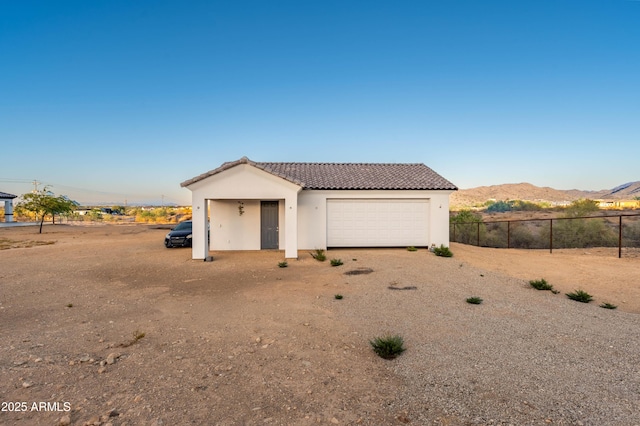 8017 S 143rd Ave, Goodyear, AZ 85338 - view of front of house with a mountain view, a tiled roof, stucco siding, and driveway