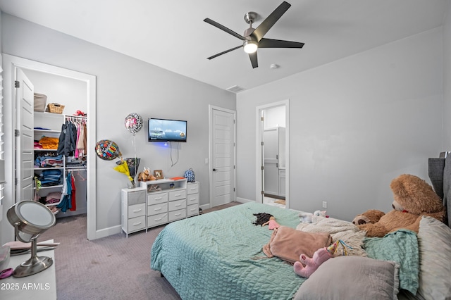 8017 S 143rd Ave, Goodyear, AZ 85338 - carpeted bedroom featuring a walk in closet, a closet, a ceiling fan, and ensuite bath