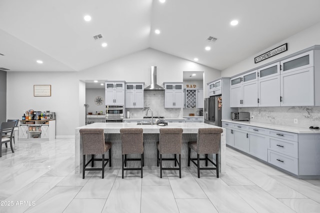8017 S 143rd Ave, Goodyear, AZ 85338 - kitchen featuring appliances with stainless steel finishes, wall chimney exhaust hood, a large island, decorative backsplash, and recessed lighting