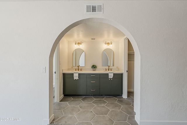 2307 W Nido Ave, Mesa, AZ 85202 - full bath with double vanity, a textured wall, baseboards, tile patterned floors, and a walk in closet