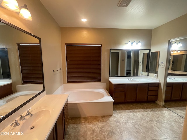 bathroom featuring a washtub, vanity, and tile patterned flooring