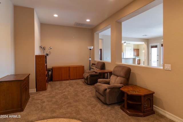 sitting room featuring carpet and ceiling fan