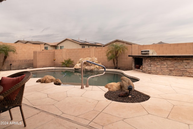 view of pool with a patio, an outdoor kitchen, and an outdoor bar