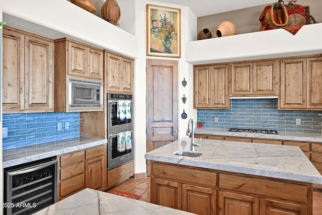 kitchen featuring light tile patterned floors, beverage cooler, stainless steel appliances, decorative backsplash, and a sink