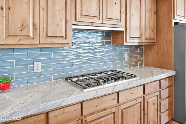 kitchen with stainless steel appliances, exhaust hood, and light brown cabinets