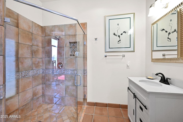 bathroom with tile patterned flooring, a shower stall, vanity, and baseboards